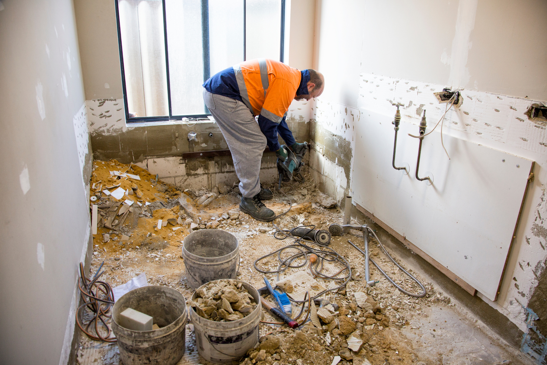 A contractor completely gutting a bathroom when renovating an old house