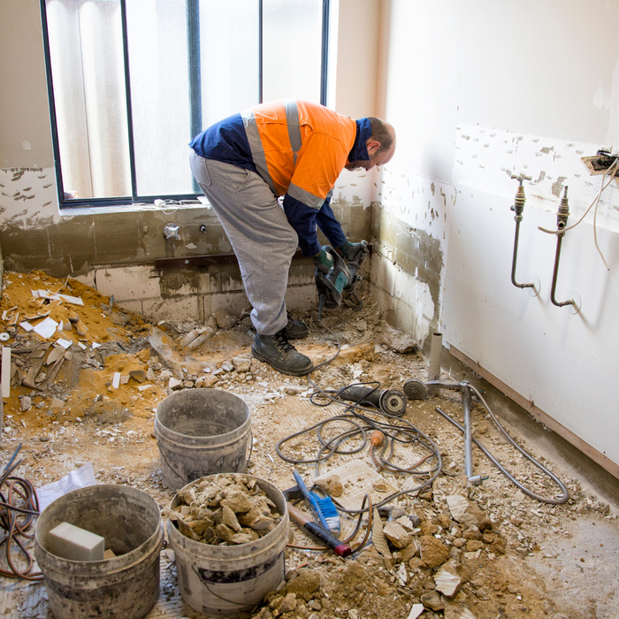 A contractor completely gutting a bathroom when renovating an old house