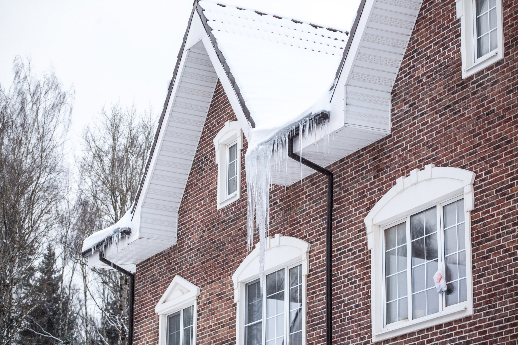 A home in the winter covered in snow and icicles