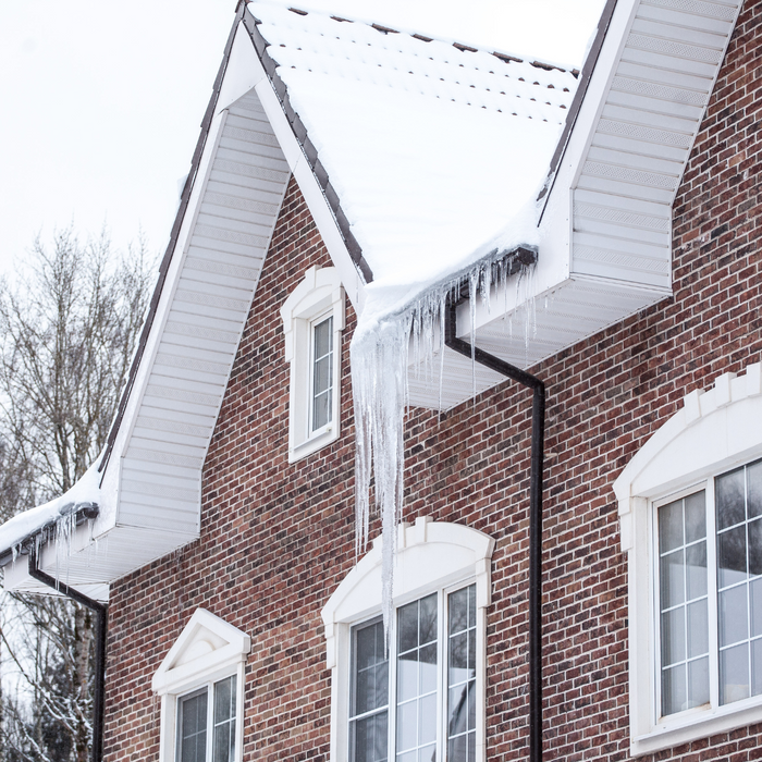 A home in the winter covered in snow and icicles
