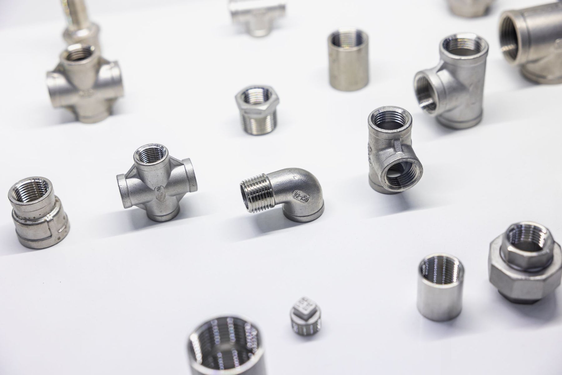 Assorted pipe fittings sprawled on top of a white background