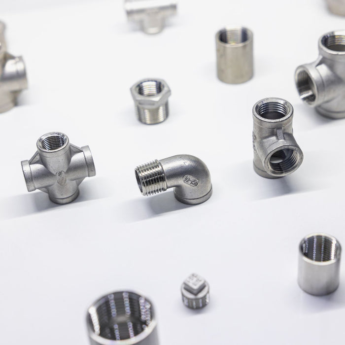 Assorted pipe fittings sprawled on top of a white background