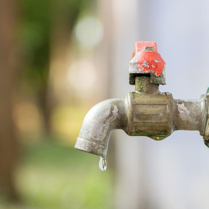 Leaking outdoor faucet with red handle